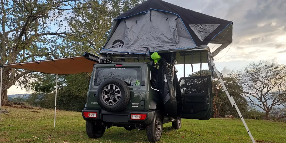vehicle parked in a meadow with tent roof